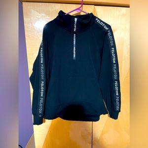 Black Peloton quarter zip sweatshirt.  Draw string bottom, kangaroo pocket.